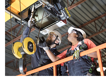 Technicians inspect overhead crane