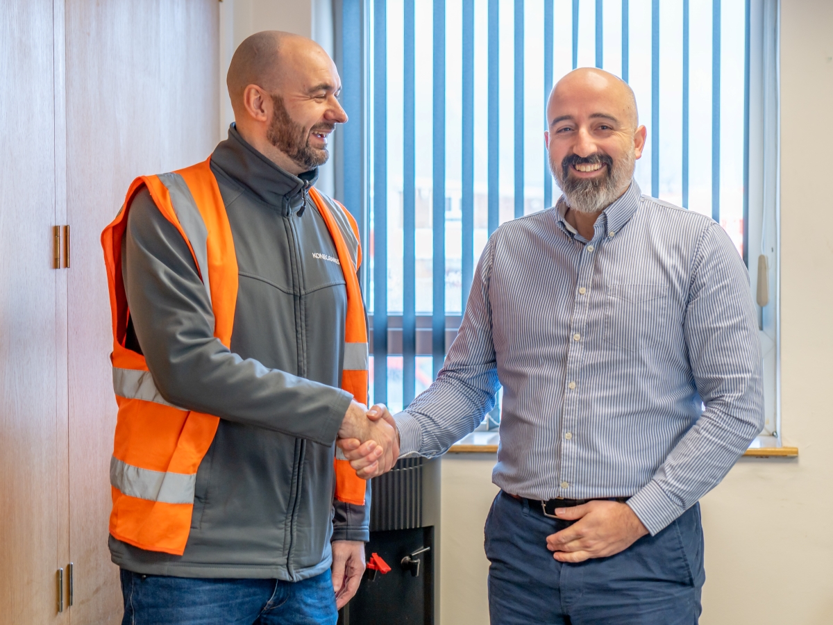 Agilon UK sales manager Antony Ward in safety west shaking hand and smiling with Speedy asset Services NSC manager Neil Cave