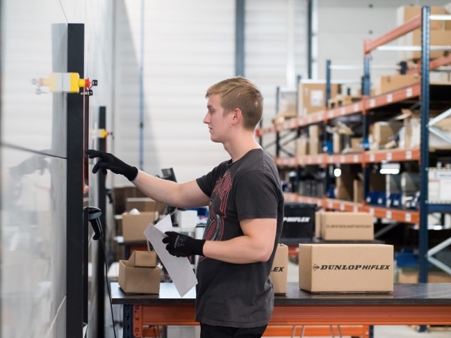 Työntekijä kerää pakkauksia Dunlop Hiflex jakelukeskuksen automaattivarasto Agilonista