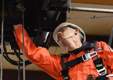 A technician inspects the overhead crane.