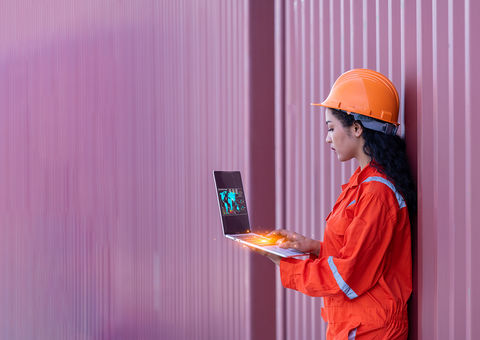 Woman on laptop in industrial setting