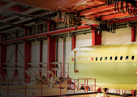 Overhead crane lifting aircraft part