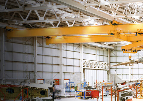 Overhead crane lifting aircraft part