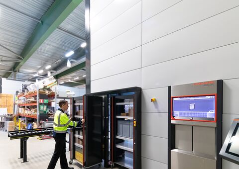 Worker using an Agilon Autoload Trolley to transport materials from receiving to an Agilon warehouse automation system