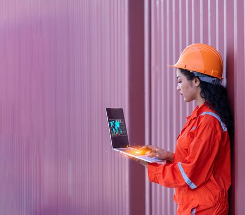 Woman on laptop in industrial setting
