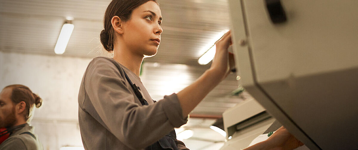 Workers using machines in warehouse