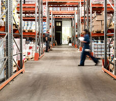 Workers walk through warehouse